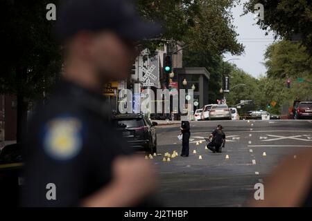 Sacramento, États-Unis. 3rd avril 2022. Des policiers enquêtent sur le site d'une fusillade à Sacramento, Californie, États-Unis, le 3 avril 2022. Six personnes ont été tuées et au moins neuf autres ont été blessées lors d'une fusillade dans le centre-ville de Sacramento, la capitale de l'État américain de Californie, a déclaré dimanche la police locale. Credit: Li Jianguo/Xinhua/Alay Live News Banque D'Images