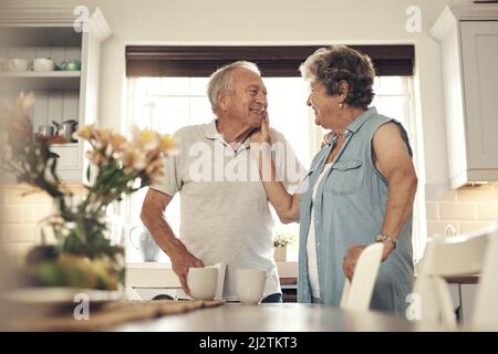 Chaque pression est aussi douce que jamais. Photo d'un couple senior prenant le petit déjeuner à la maison. Banque D'Images