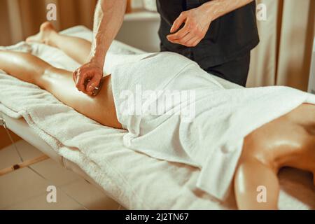 Jeune femme recevant un massage sous vide des jambes avec les tasses spéciales. Massage chinois Banque D'Images