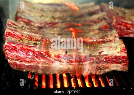 côtelettes de bœuf angus américain marinées aux épices sur un barbecue à la flamme Banque D'Images