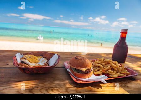 Beach fast food restaurant shake Shack bar vue sur les hamburgers et les frites sur la table avec vue sur l'océan à Bora Bora, Tahiti. Polynésie Island voyage Banque D'Images