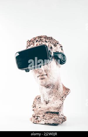 Statue ancienne avec lunettes VR sur fond blanc. Concept d'art et réalité virtuelle. Banque D'Images