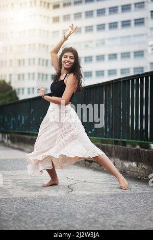 Elle se déplace avec une grâce captivante. Portrait d'une jeune femme attrayante dansant dans la ville. Banque D'Images