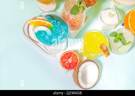 Ensemble de boissons estivales colorées. Divers cocktails et boissons alcoolisés, dans différents verres, avec fruits tropicaux sur fond moderne et lumineux Banque D'Images