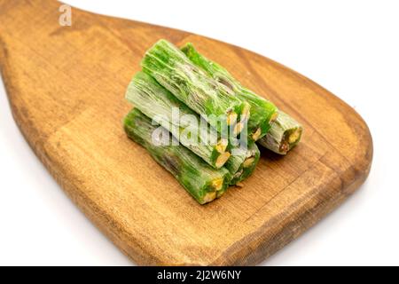 Les doigts de Kiwi délient turc avec des pistaches isolées sur un fond blanc. Pistache en gros plan délice turc. Cuisine turque traditionnelle fine Banque D'Images