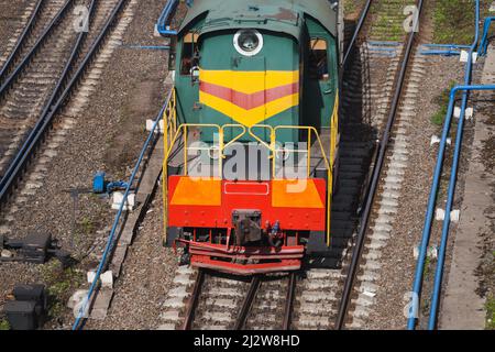 La locomotive diesel se déplace sur un chemin de fer sur une journée ensoleillée, vue aérienne Banque D'Images