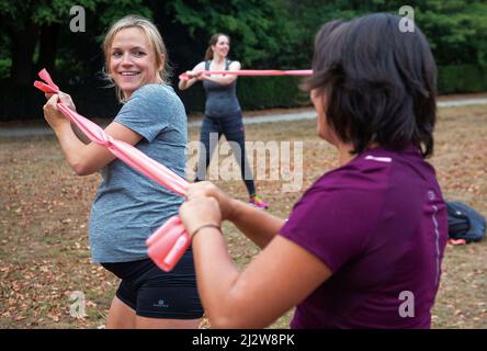 Pays-Bas, Arnhem - camp d'entraînement des femmes enceintes dans un parc. Formateur de 'Mom in balance 'instruisant l'une des pièces de formation de bootcamp. Banque D'Images