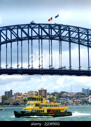 Australie, Sydney - avec le drapeau national australien et le drapeau aborigène au-dessus du pont du port, les touristes grimpent sur le pont en acier, qui Banque D'Images