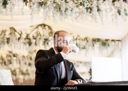 un homme beau et réussi en costume boit de l'espresso. un homme élégant et élégant Banque D'Images