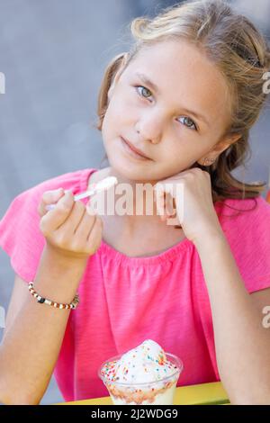 Blanche fille blonde dans un chemisier rose avec de la crème glacée. Photo de haute qualité Banque D'Images