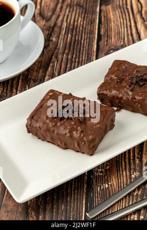 Gâteau au raisin recouvert de chocolat sur table en bois avec café filtre Banque D'Images