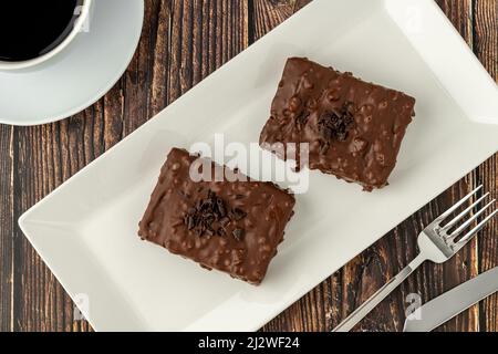 Gâteau au raisin recouvert de chocolat sur table en bois avec café filtre Banque D'Images