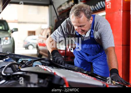 Mechanic repairing car Banque D'Images