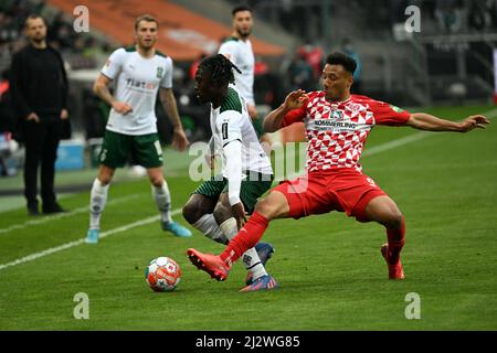 03 avril 2022, Rhénanie-du-Nord-Westphalie, Mönchengladbach: Football: Bundesliga, Borussia Mönchengladbach - FSV Mainz 05, Matchday 28, Stade im Borussia-Park. Kouadio Kone (l) de Mönchengladbach et Karim Onisiwo de Mayence se battent pour le ballon. Photo: Federico Gambarini/dpa Banque D'Images