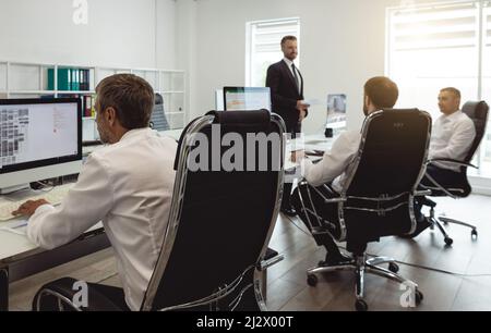 Le directeur général et les employés de l'entreprise interagissent et parlent au bureau. Réunion du responsable avec le personnel pour discuter des tâches Banque D'Images