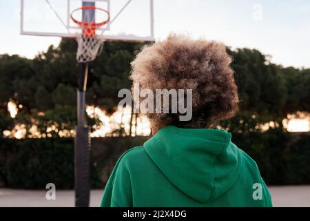 vue arrière d'une personne méconnaissable sur le terrain de basket-ball d'un parc de la ville, concept de sport urbain dans la rue, espace pour le texte Banque D'Images