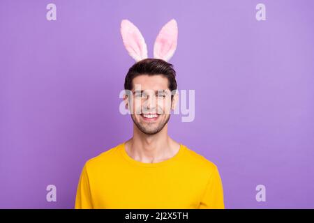 Portrait d'un bel homme childish enjoué et insouciant avec un bandeau de lapin isolé sur fond violet Banque D'Images