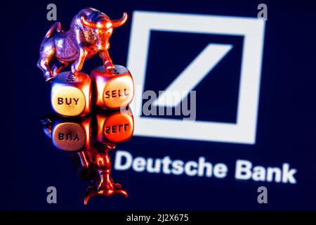 Le taureau métallique se dresse sur des dés d'achat-vente sur fond du logo de la Deutsche Bank Banque D'Images