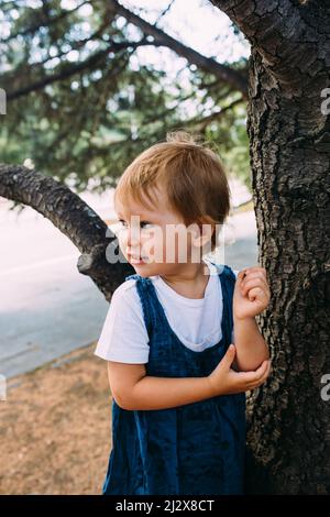 Petite fille marche dans le jardin parmi de belles plantes vertes du sud Banque D'Images