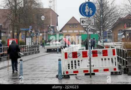 04 avril 2022, Mecklembourg-Poméranie occidentale, Warnemünde : une clôture de construction sera érigée sur le pont tournant au-dessus de l'Alter Strom pour séparer le chantier. Les travaux de réparation du monument auront lieu jusqu'en juillet 2022. Les planches en bois du trottoir de la passerelle latérale doivent être renouvelées et des travaux de protection contre la corrosion seront effectués sur la structure en acier de la superstructure. Le jeu de couleurs doit être conservé conformément à la conception originale du monument. Photo: Bernd Wüstneck/dpa-Zentralbild/ZB Banque D'Images