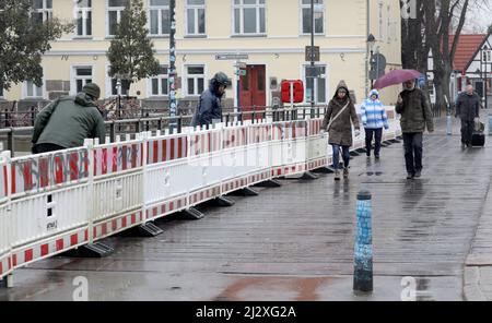 04 avril 2022, Mecklembourg-Poméranie occidentale, Warnemünde : une clôture de construction sera érigée sur le pont tournant au-dessus de l'Alter Strom pour séparer le chantier. Les travaux de réparation du monument auront lieu jusqu'en juillet 2022. Les planches en bois du trottoir de la passerelle latérale doivent être renouvelées et des travaux de protection contre la corrosion seront effectués sur la structure en acier de la superstructure. Le jeu de couleurs doit être conservé conformément à la conception originale du monument. Photo: Bernd Wüstneck/dpa-Zentralbild/ZB Banque D'Images