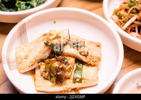 Kimchi épicé. Légumes de cornichon coréen ou de radis marinés et assaisonnement sur un bol sur fond de table en bois, cuisine japonaise Banque D'Images