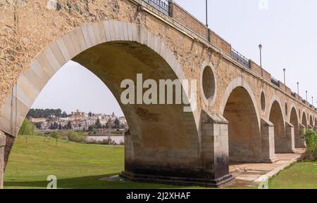 Badajoz, Espagne - 27 mars 2022 : le pont historique Puente de Palmas datant du 15 siècle avec vue sur la vieille ville à travers l'une des arches Banque D'Images