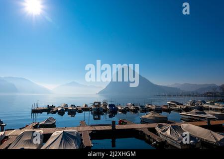 Port et montagne pic Monte San Salvatore dans la ville de Lugano sur le lac de Lugano dans une Misty Sunny Day au Tessin, Suisse. Banque D'Images