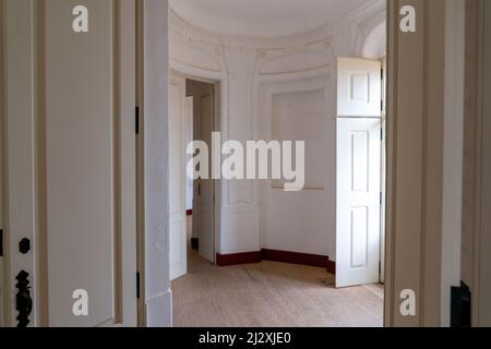 Alcacova, Portugal - 25 mars. 2022: Élégante salle ronde vide avec parquet, grands murs blancs et grandes portes-fenêtres Banque D'Images