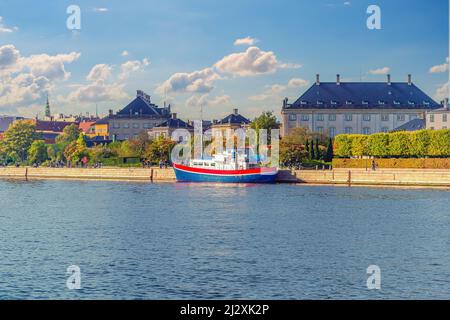Un vieux navire se trouve dans un chenal d'eau près du remblai avec des arbres et des maisons à Copenhague, au Danemark Banque D'Images