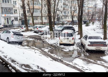 Russie, Vladivostok, 21 mars 2022. Voitures dans un parking sale après la neige. Les zones pauvres de la ville et les problèmes d'infrastructure. Transport et véhicules. Banque D'Images