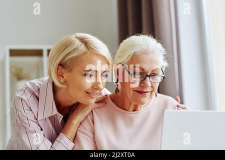 Gros plan portrait d'une jeune femme avec une mère âgée utilisant l'ordinateur ensemble à la maison et les achats en ligne Banque D'Images