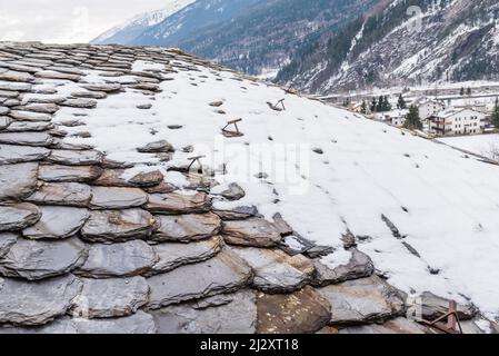 Vieux tuiles de toit gris, partiellement couvert de neige, fond. Banque D'Images