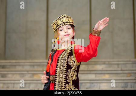 Une petite fille en costume national ouzbek danse. Banque D'Images