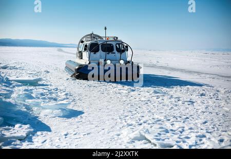 Transport d'hiver Khivus sur glace. Aéroglisseur. Glace à la surface du lac Baikal gelé transparent. Ciel bleu. Horizon. Horizontale. Baikal en hiver. Banque D'Images