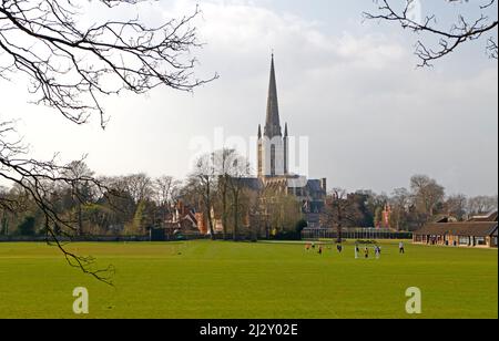 Vue sur la cathédrale de l'autre côté de l'école de Norwich avec match de football junior dans la ville de Norwich, Norfolk, Angleterre, Royaume-Uni. Banque D'Images