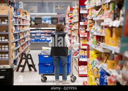 Supermarché Super U : femme, préparateur de commande préparant un panier pour un client qui a passé sa commande en ligne Banque D'Images