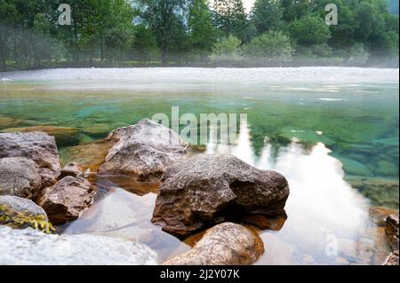 Vue à angle bas d'une belle rivière calme et verte avec des rochers qui la regardent et une nature verte lumineuse en arrière-plan. Banque D'Images