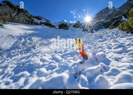 Une femme en excursion de ski descend sur une avalanche de neige, Gamsjoch, Karwendel, parc naturel de Karwendel, Tyrol, Autriche Banque D'Images