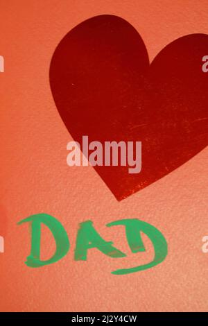 Une carte orange avec coeur rouge et papa écrit en stylo feutre vert Banque D'Images