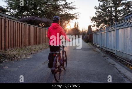 Femme aventureuse debout avec un vélo dans une allée dans la banlieue de Modery City Banque D'Images