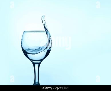 verre d'eau propre avec une éclaboussure sur un arrière-plan clair avec un espace de copie Banque D'Images