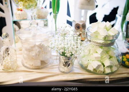 Bar à bonbons de mariage avec fleurs blanches dans un style rustique Banque D'Images
