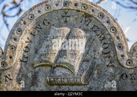 Détail livre sur une pierre tombale dans le cimetière de l'église St Nonna, Bradstone, Devon, Angleterre, Royaume-Uni Banque D'Images