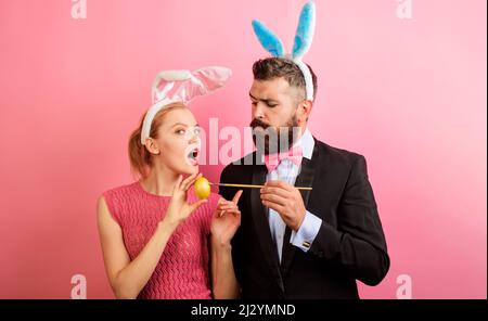 Bonne famille fêtez Pâques. Un couple de lapins peint un œuf pour les vacances. Décoration des œufs idées. Banque D'Images