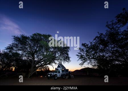 Camping autour d'un feu de camp sous un ciel étoilé, Twyfelfontein, Namibie Banque D'Images