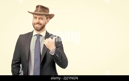 Homme d'affaires heureux dans chapeau de cowboy et costume sourire pointant le doigt de publicité geste, de la publicité Banque D'Images