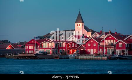 Maisons rouges avec une église dans le village de Skärhamn sur l'archipel de Tjörn sur la côte ouest de la Suède, dans la soirée Banque D'Images