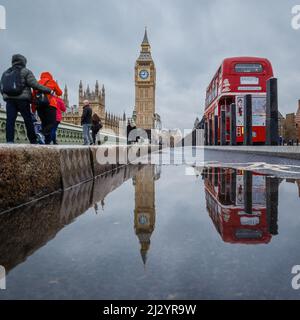 Westminster se reflète dans une flaque sur le pont de Westminster, Londres. Banque D'Images