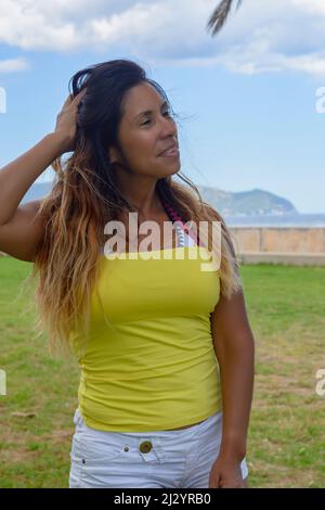 belle et heureuse femme latine avec de longs cheveux souriants, ayant un bon moment, en vacances à majorque vacances concept Banque D'Images